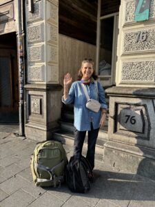 Standing with my green suitcase on a street in Amsterdam.