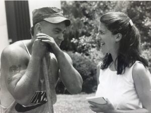 Tzivia talking to a construction worker, reporter's notebook in hand.